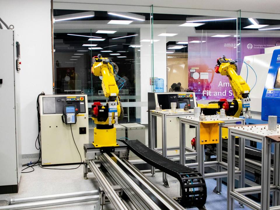 Brazos robóticos en acción dentro de una moderna sala de control industrial, mostrando tecnología y producción.