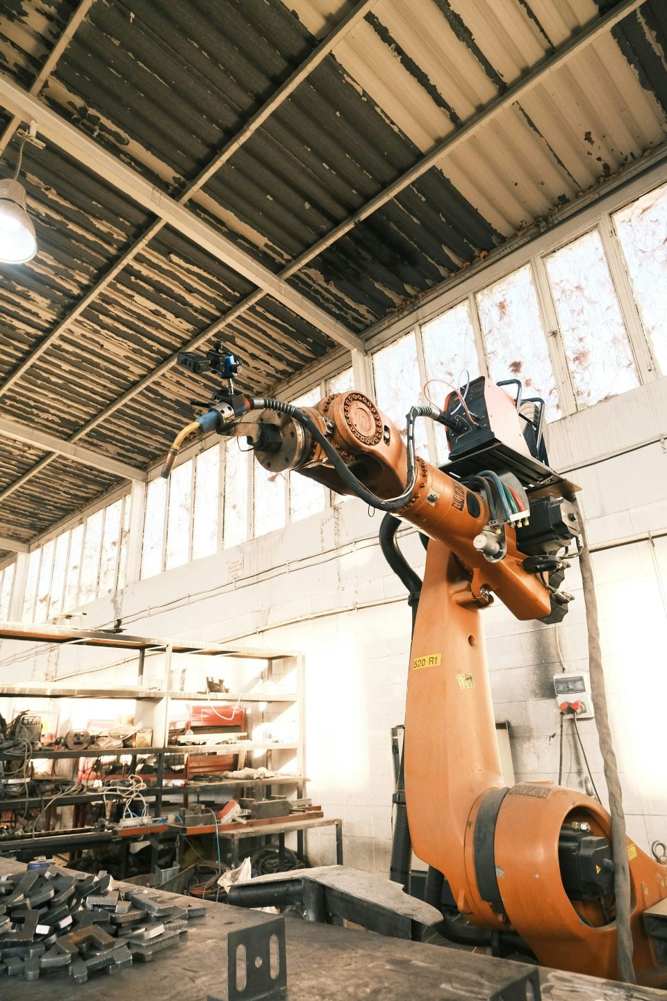 Un gran robot naranja en un edificio con muchas herramientas.
